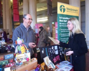 Roger of the Beehive shop serves customers at the Fair Trade Fair